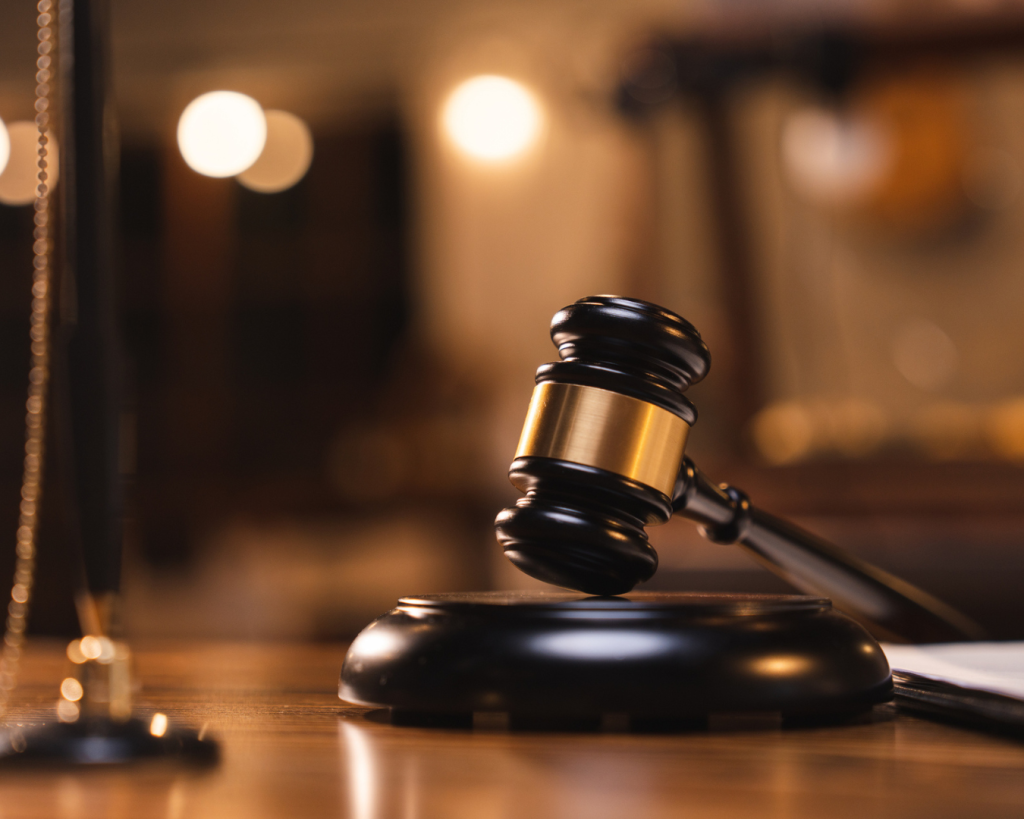 Close up shot of gavel on judge's desk in dark courtroom.