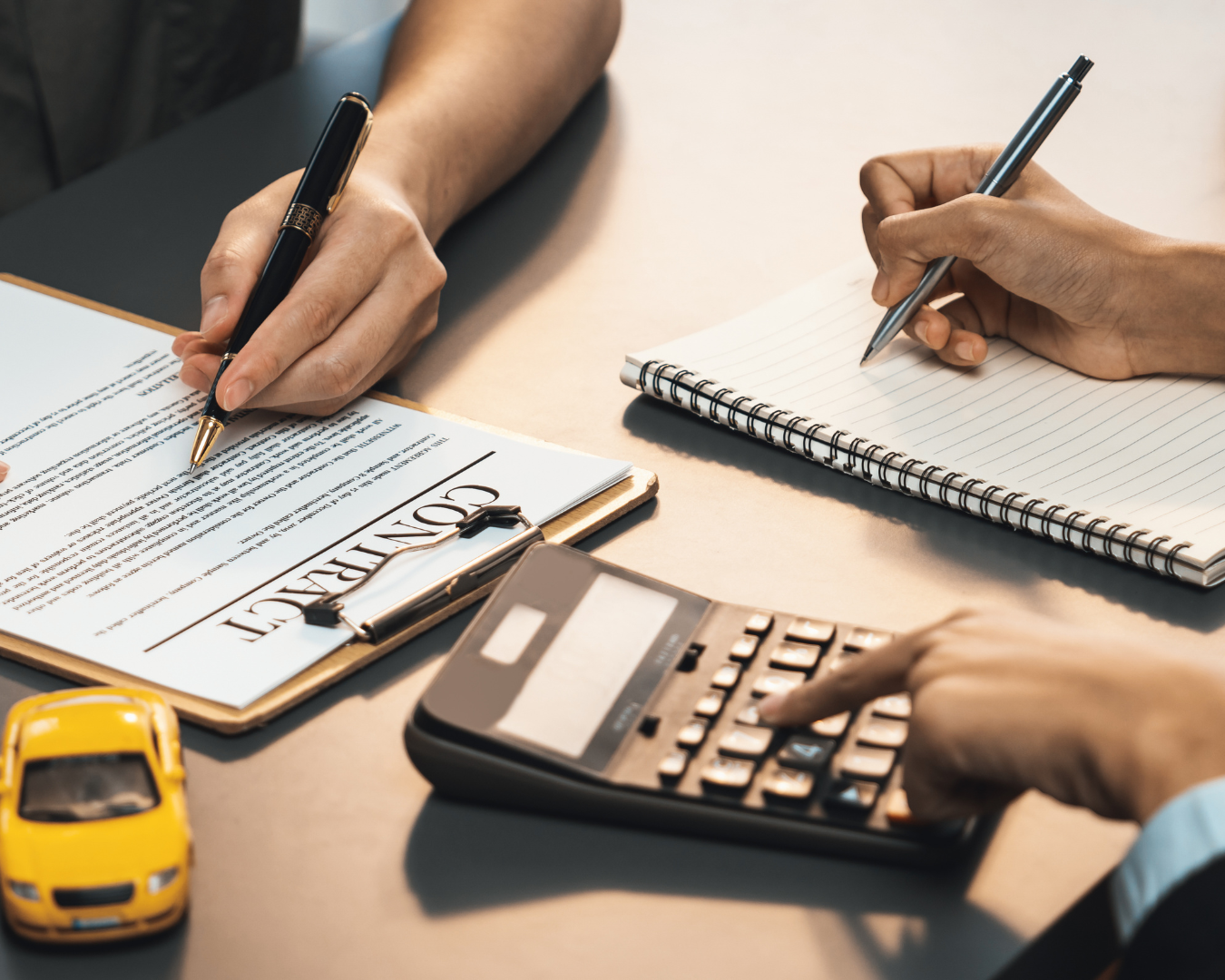 Close up of insurance agent crunching numbers in calculator as client goes over contract.