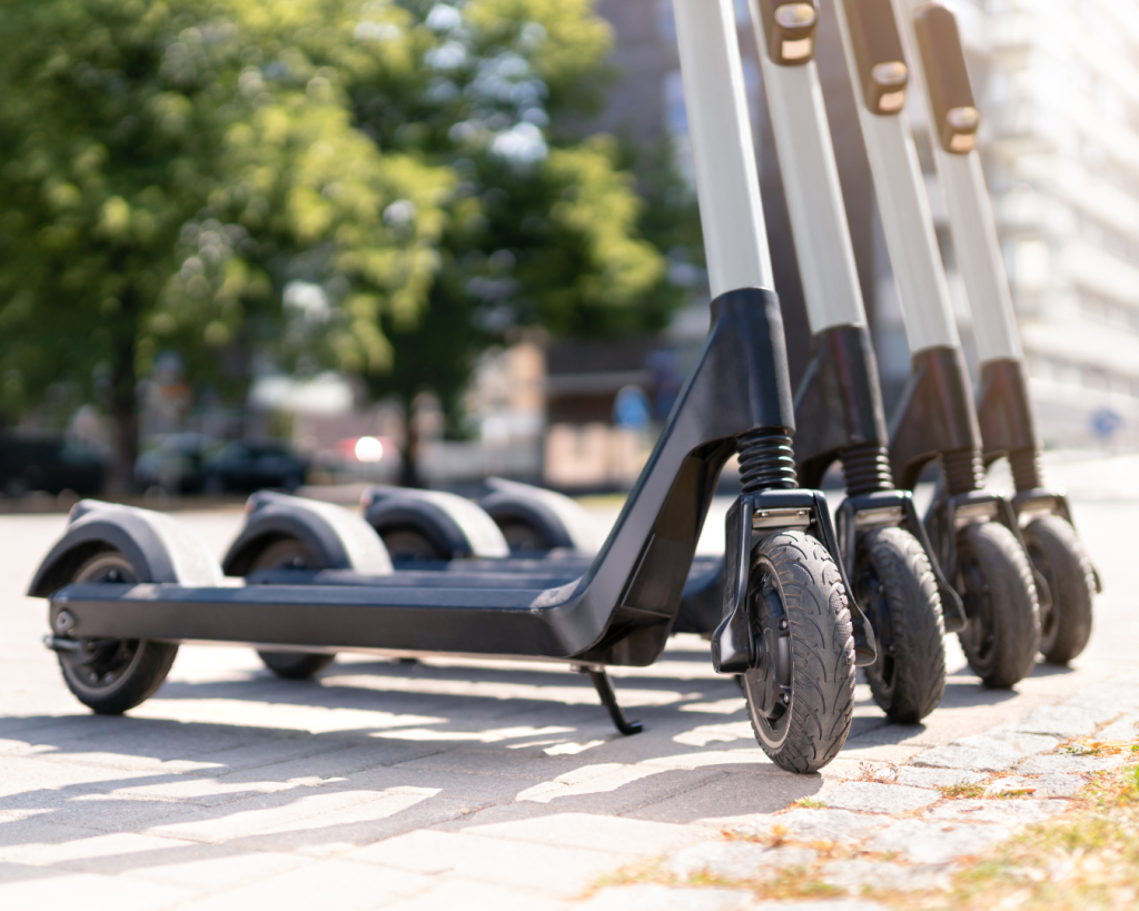 Line of e-scooters lined up on sidewalk.